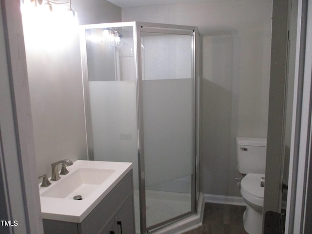 bathroom featuring vanity, an enclosed shower, and toilet