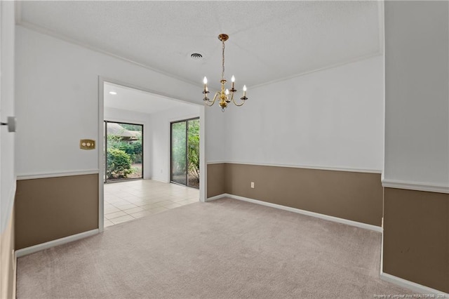 carpeted spare room with a notable chandelier