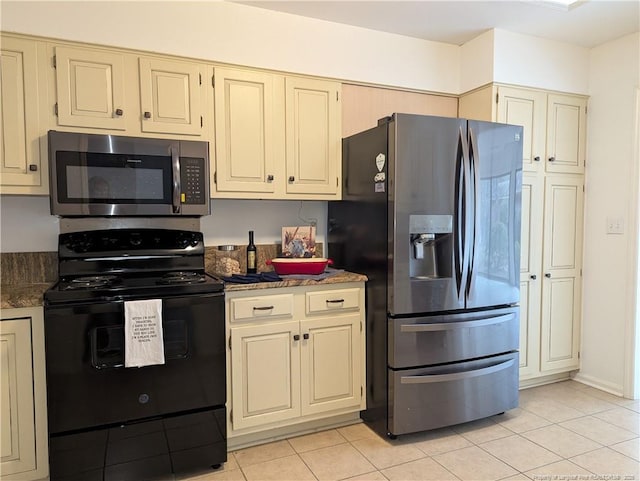 kitchen with cream cabinetry, stainless steel appliances, and light tile patterned flooring