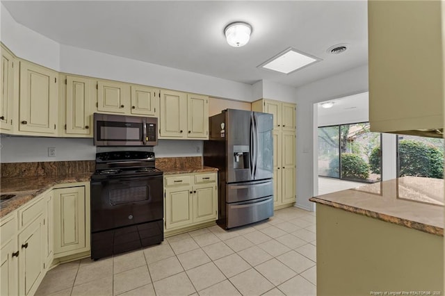 kitchen featuring cream cabinets, stainless steel appliances, and light tile patterned floors