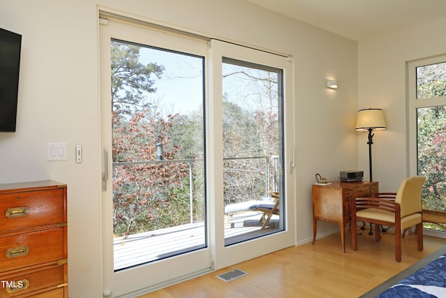 entryway with light wood-style floors, visible vents, and a wealth of natural light