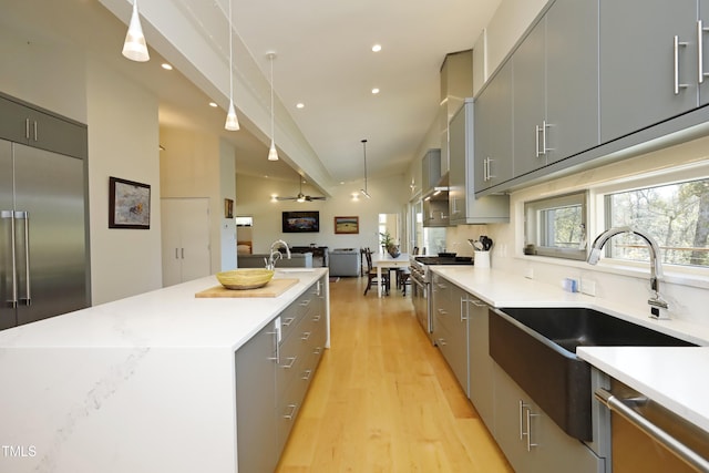 kitchen with modern cabinets, premium appliances, gray cabinetry, and a center island