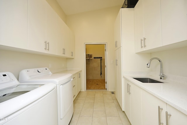 washroom featuring washer and clothes dryer, light tile patterned flooring, cabinet space, and a sink