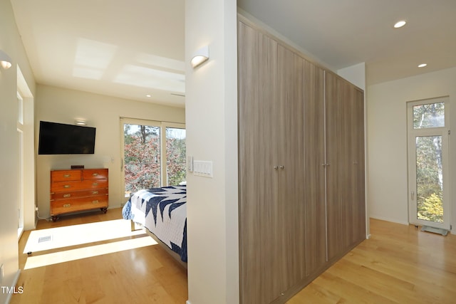 bedroom featuring light wood-style flooring, multiple windows, and recessed lighting