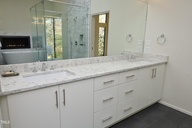 bathroom with double vanity, tile patterned flooring, a stall shower, and a sink