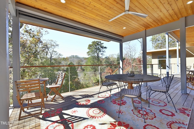 sunroom featuring wooden ceiling and a ceiling fan