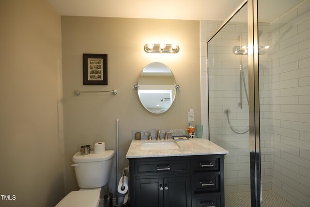 bathroom with toilet, a stall shower, and vanity