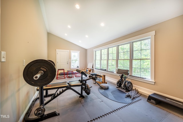 workout room featuring vaulted ceiling, baseboards, and a wealth of natural light