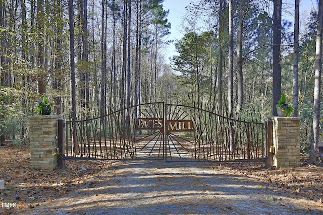 view of gate with a wooded view