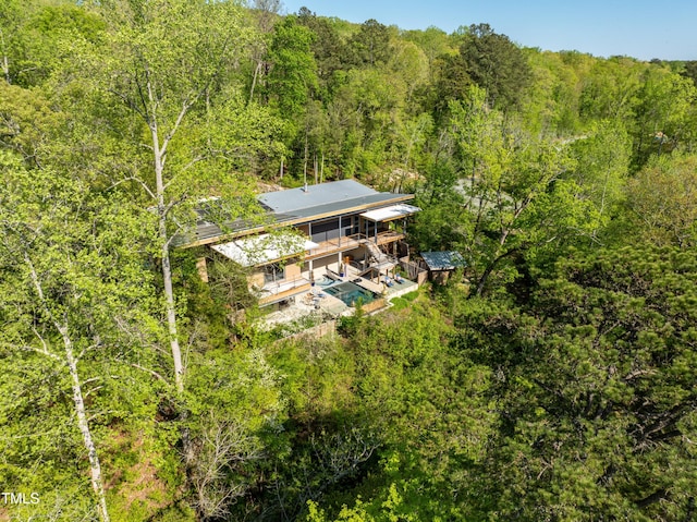 bird's eye view with a wooded view