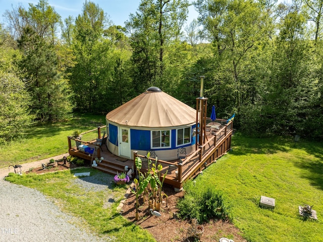 view of front of property featuring a deck, a front yard, driveway, and metal roof