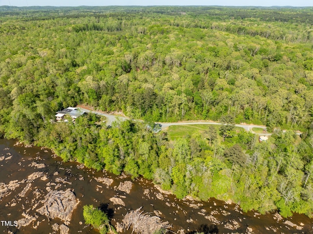 birds eye view of property featuring a wooded view and a water view