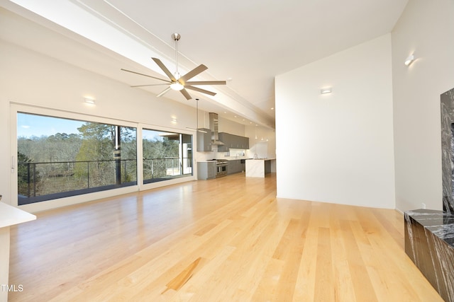 unfurnished living room featuring light wood-style flooring and a ceiling fan