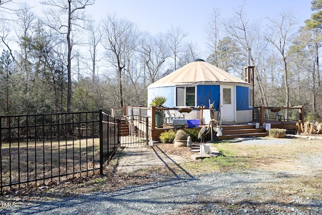 view of front of home featuring metal roof, a deck, and fence