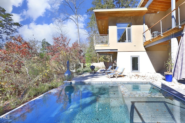 view of pool featuring a jacuzzi and a patio