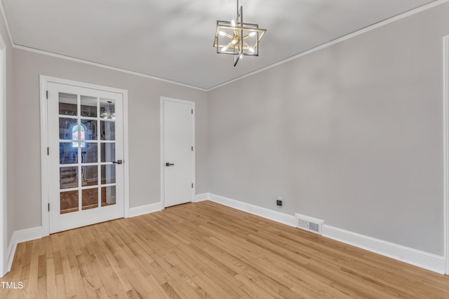 empty room featuring light hardwood / wood-style flooring, ornamental molding, and a chandelier