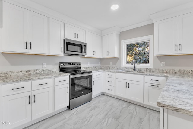 kitchen featuring stainless steel appliances, ornamental molding, white cabinetry, and sink