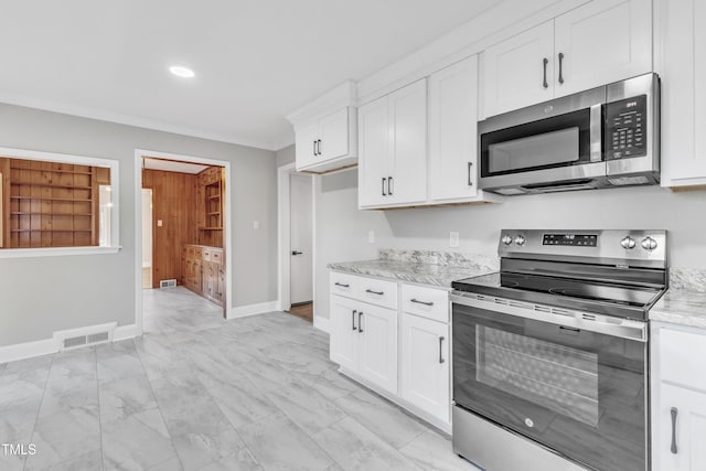 kitchen with ornamental molding, light stone counters, stainless steel appliances, and white cabinetry