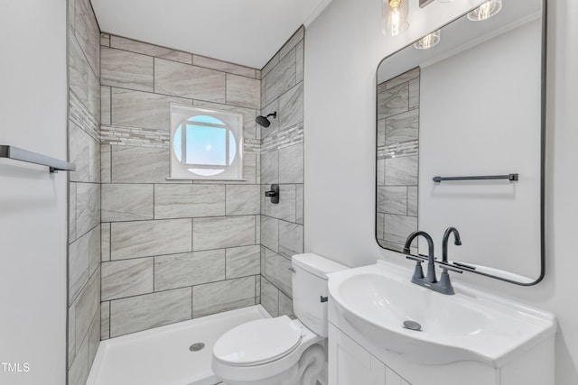 bathroom featuring toilet, vanity, and tiled shower