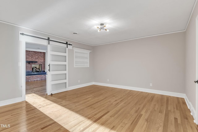 spare room with an inviting chandelier, ornamental molding, hardwood / wood-style floors, and built in shelves