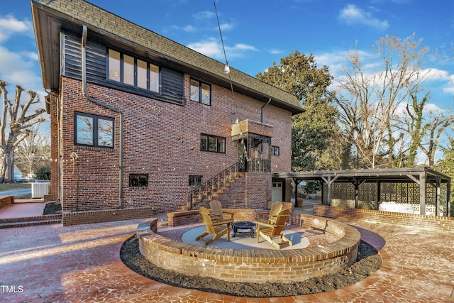 rear view of house featuring an outdoor fire pit, central AC unit, and a patio