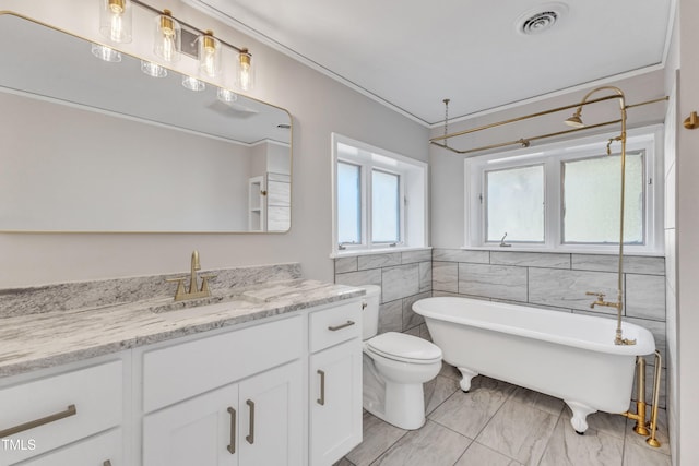 bathroom with toilet, tile walls, crown molding, a washtub, and vanity