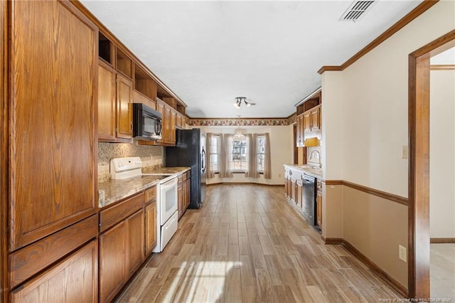 kitchen featuring light stone countertops, light wood-type flooring, backsplash, crown molding, and black appliances