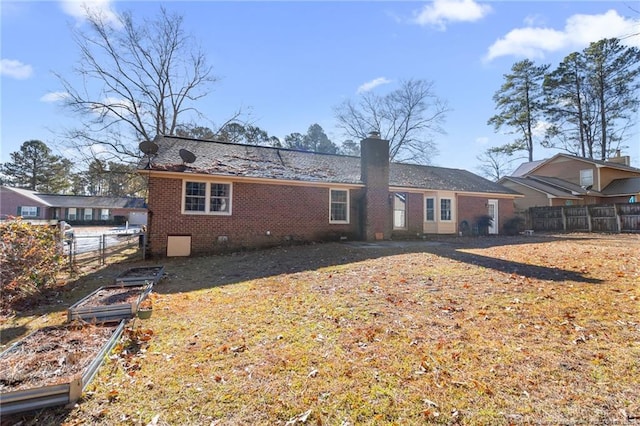 rear view of property featuring a lawn