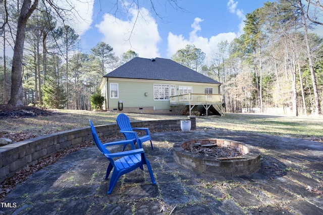 back of house with a deck and an outdoor fire pit