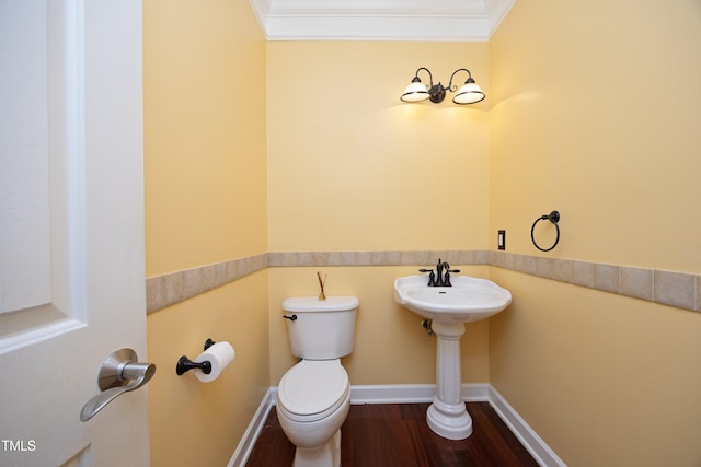 bathroom with hardwood / wood-style floors, toilet, and crown molding