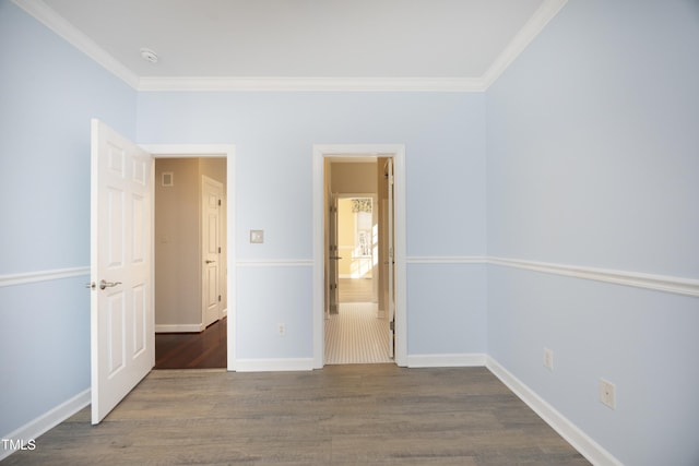 unfurnished bedroom with dark wood-type flooring, ensuite bath, and crown molding