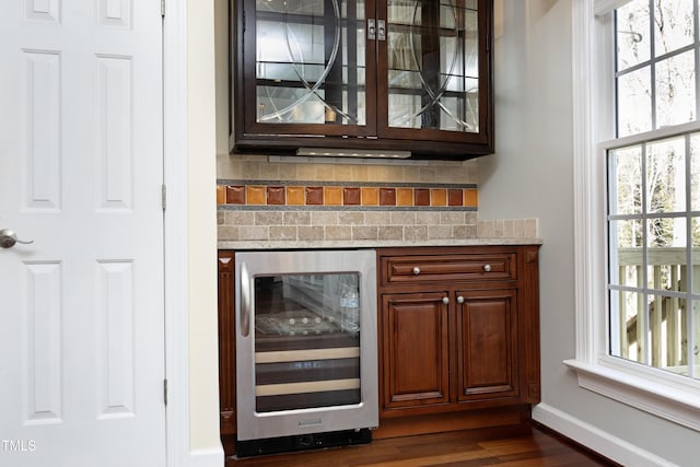 bar with dark wood-type flooring and beverage cooler