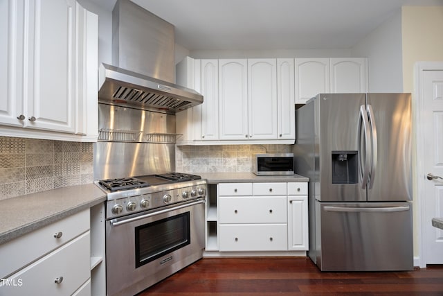 kitchen with white cabinets, stainless steel appliances, tasteful backsplash, and wall chimney range hood