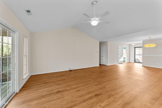 unfurnished living room featuring ceiling fan, a healthy amount of sunlight, lofted ceiling, and light hardwood / wood-style flooring