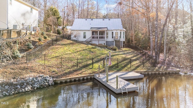 view of dock with a water view and a lawn