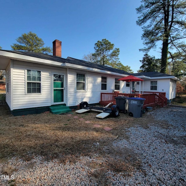 back of house featuring a deck and a chimney