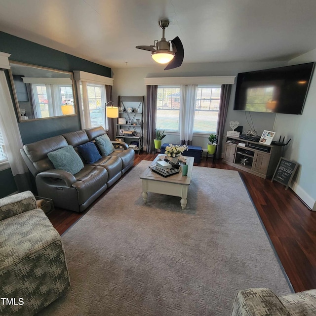 living room featuring a ceiling fan, plenty of natural light, baseboards, and wood finished floors