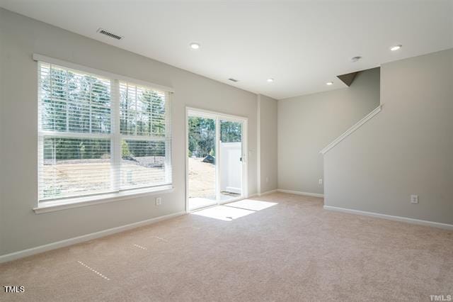 1009 Manorhaven Dr, Durham, NC 27703 - unfurnished living room with light colored carpet and recessed lighting