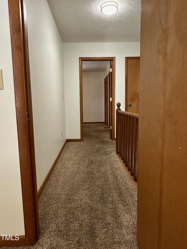 corridor featuring carpet and a textured ceiling