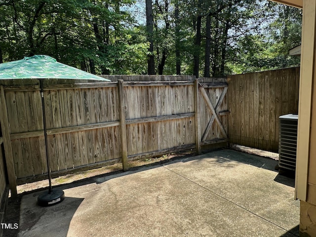 view of gate featuring a patio and central AC