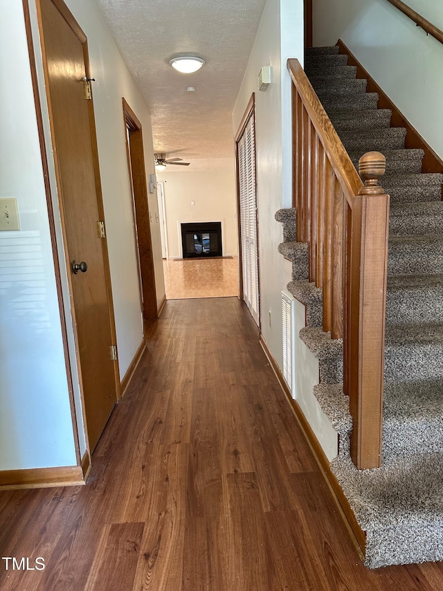 hallway featuring dark wood-type flooring and a textured ceiling