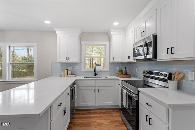 kitchen featuring white cabinetry, appliances with stainless steel finishes, sink, and backsplash