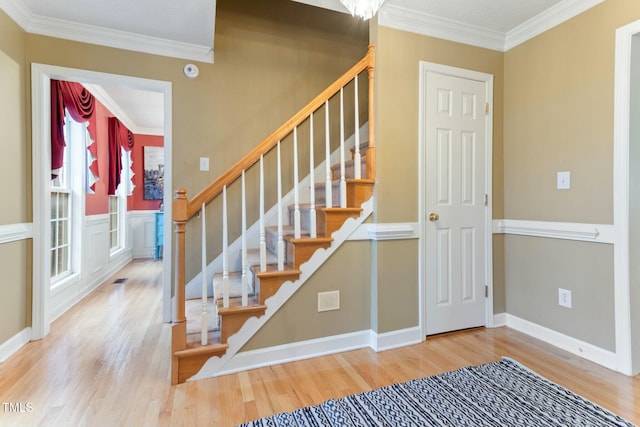 stairs featuring hardwood / wood-style flooring and crown molding