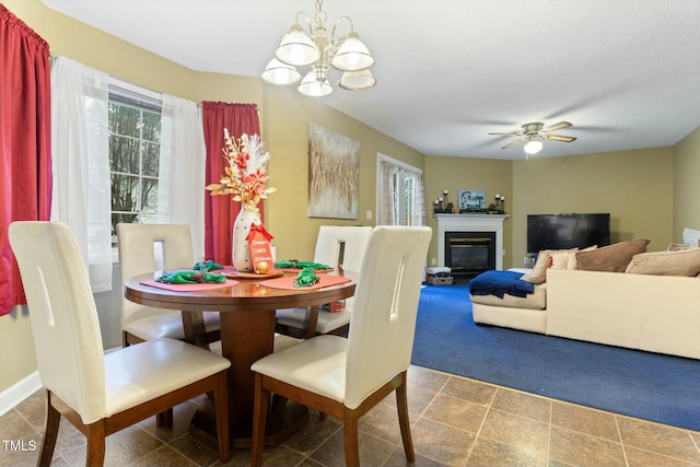 dining room with ceiling fan with notable chandelier