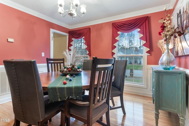 dining room featuring a chandelier, wood-type flooring, and ornamental molding