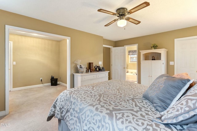 bedroom featuring light carpet, ensuite bath, and ceiling fan