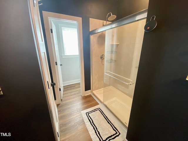 bathroom with wood-type flooring and an enclosed shower