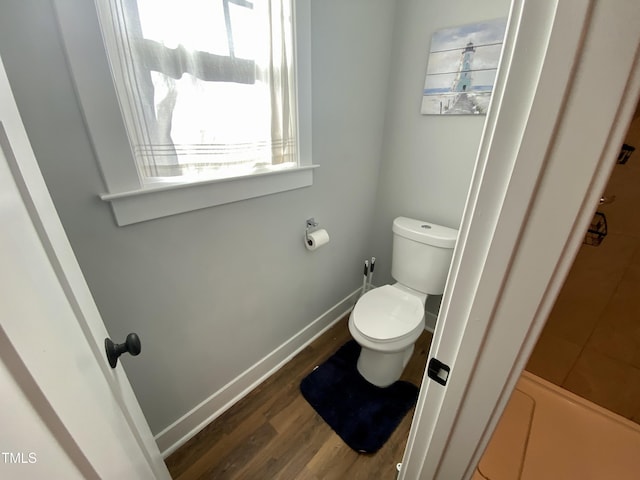 bathroom with hardwood / wood-style flooring and toilet