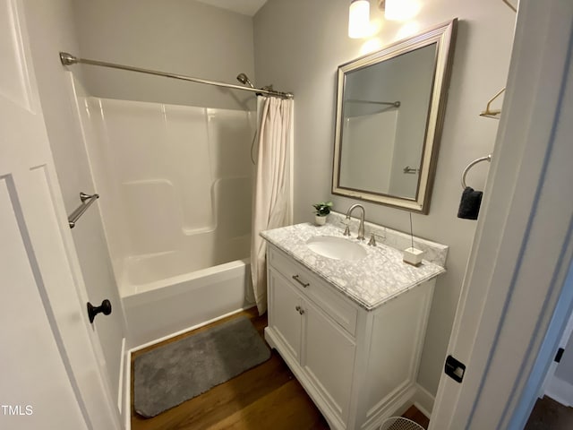 bathroom featuring wood-type flooring, vanity, and shower / bath combo with shower curtain