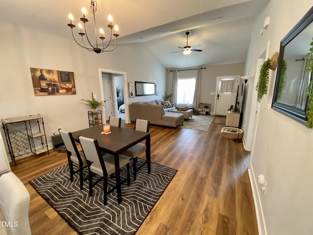 dining room with dark hardwood / wood-style flooring, ceiling fan with notable chandelier, and vaulted ceiling